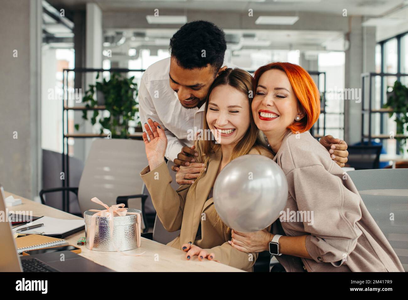 Das Business-Team feiert den Geburtstag eines Kollegen mit einem Kuchen im Büro. Den Geburtstag eines Mitarbeiters am Arbeitsplatz feiern. Stockfoto