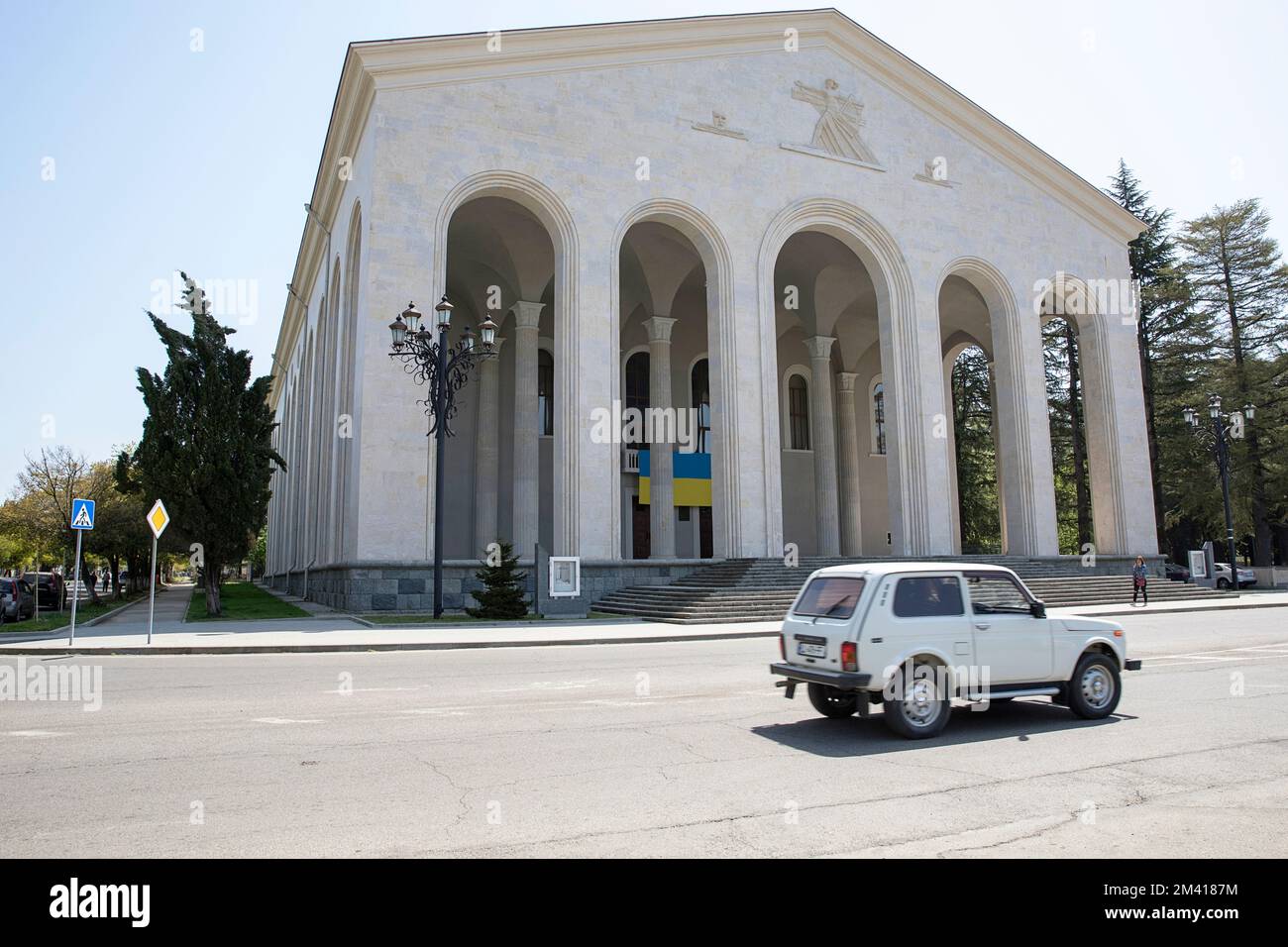 Lada Niva aus der sowjetära fährt am Ozurgeti Drama Theater in der Stadt Ozurgeti in Guria, Georgia Stockfoto