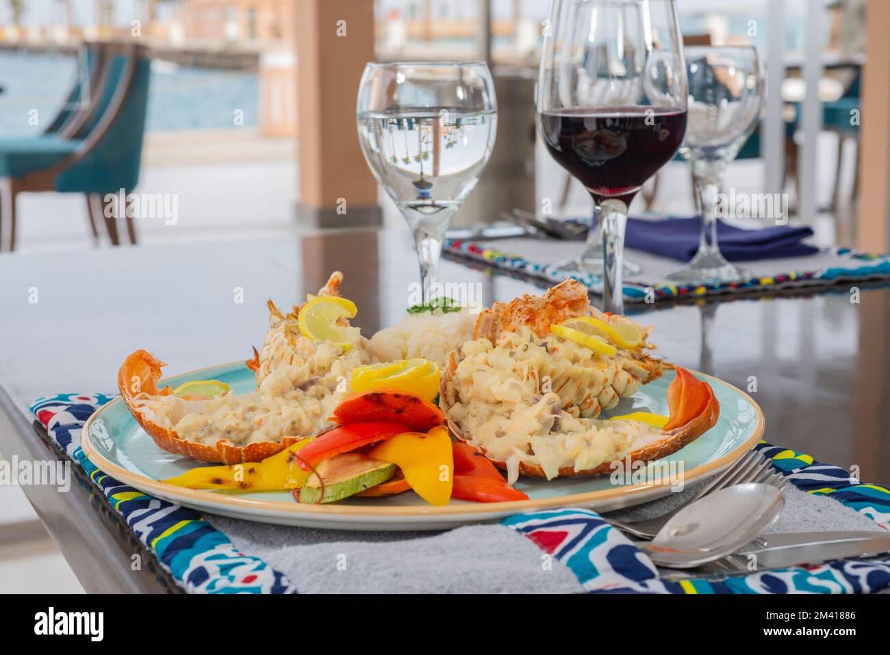 Gefülltes Hummergericht a la Carte mit weißem Reis und Gemüse am Restauranttisch Stockfoto