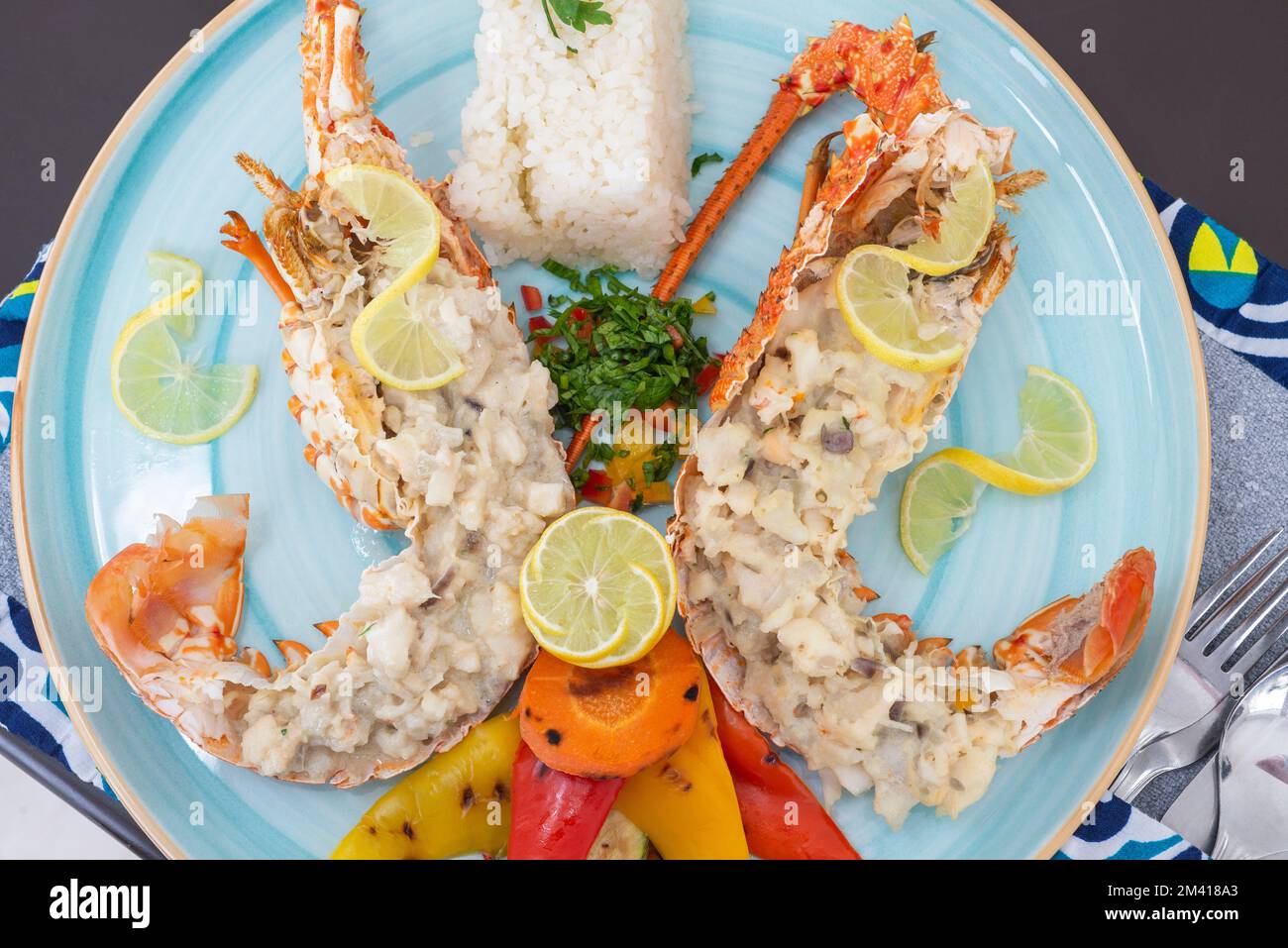 Gefülltes Hummergericht a la Carte mit weißem Reis und Gemüse am Restauranttisch Stockfoto