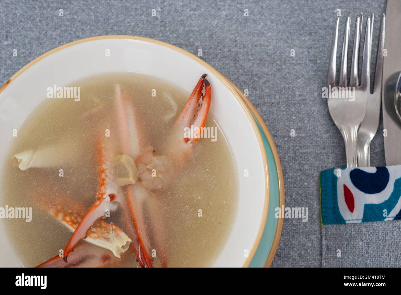 Krabbensuppe mit Meeresfrüchten, Vorspeise a la Carte in Schüssel mit Besteck am Restauranttisch Stockfoto