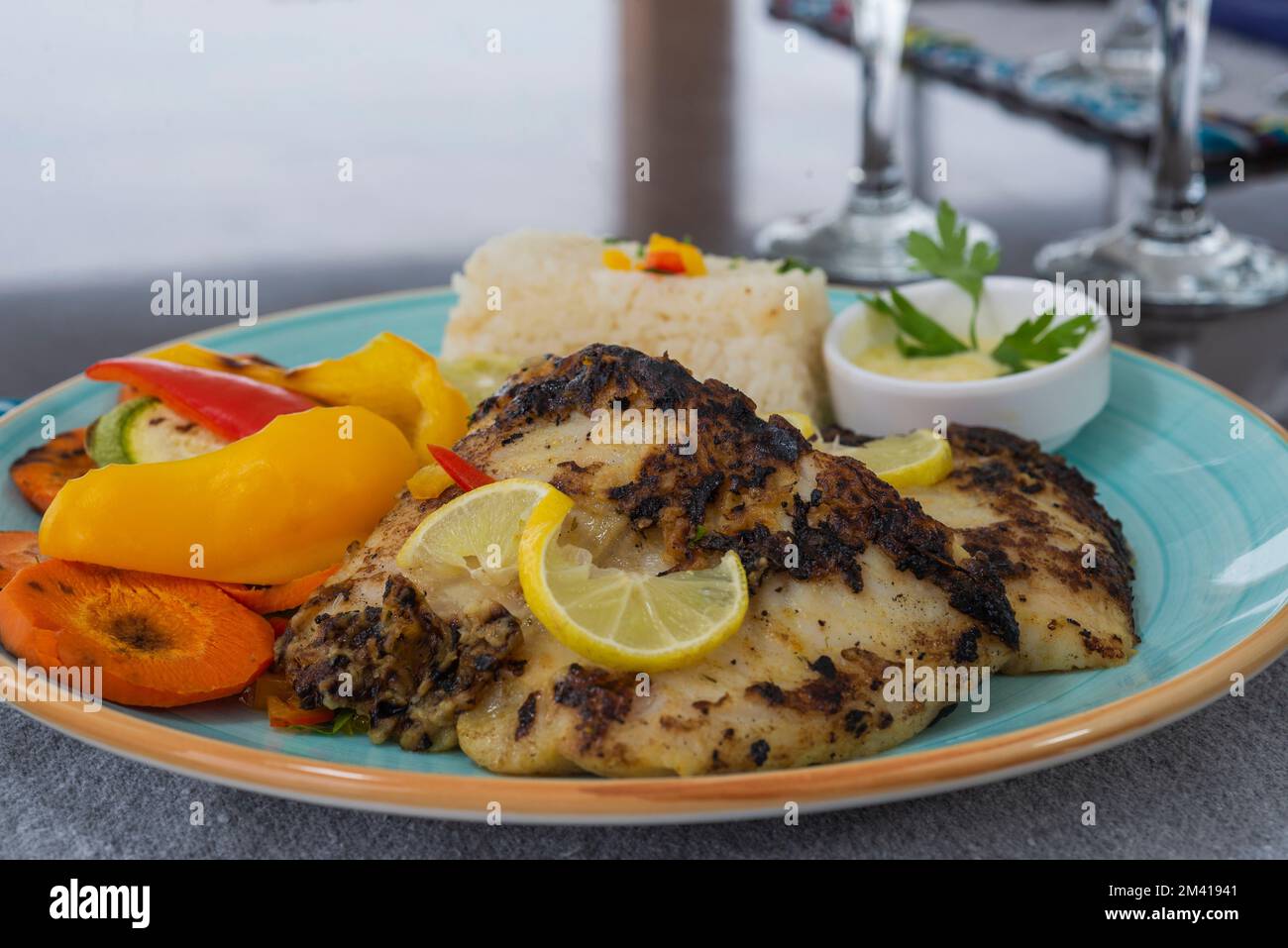 Gegrilltes Fischsteak a la Carte mit Gemüse und Kartoffelpüree am Restauranttisch Stockfoto