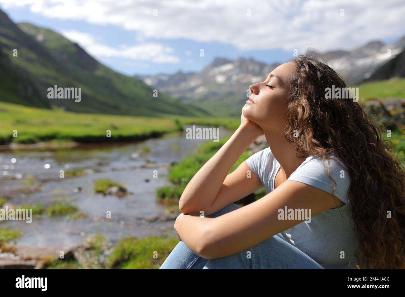 Profil einer entspannten Frau mit geschlossenen Augen am Flussufer Stockfoto