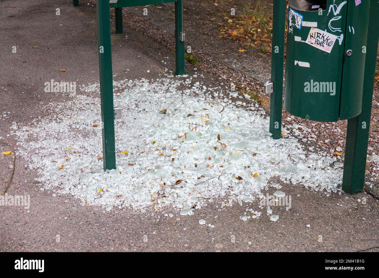 Scherben auf dem Boden rund um die vandalistische Bushaltestelle im Vähuh-Meilahti-Bezirk Helsinki, Finnland Stockfoto