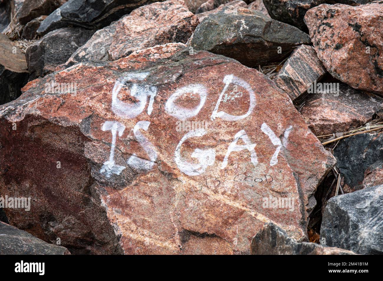 Gott ist schwul. Graffiti auf Hietaniemi Beach Rock in Helsinki, Finnland. Stockfoto