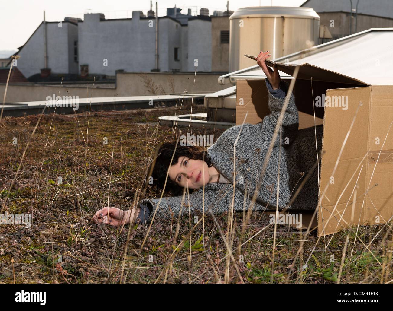 Die österreichische Filmemacherin Marie Kreutzer liegt in einer Kiste auf einem Dach in Wien. Stockfoto