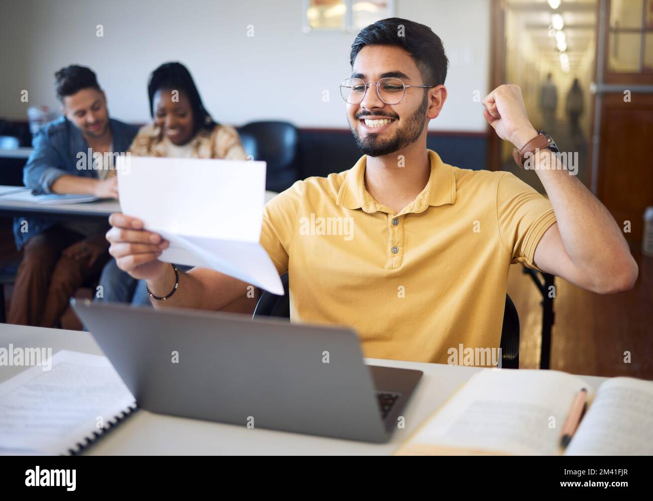 Mann, Student und begeistert mit Brief, Laptop zum Schreiben und Leistung für ein Stipendium. Indischer Mann, Dokumentation mit positivem Ausgang und Stockfoto