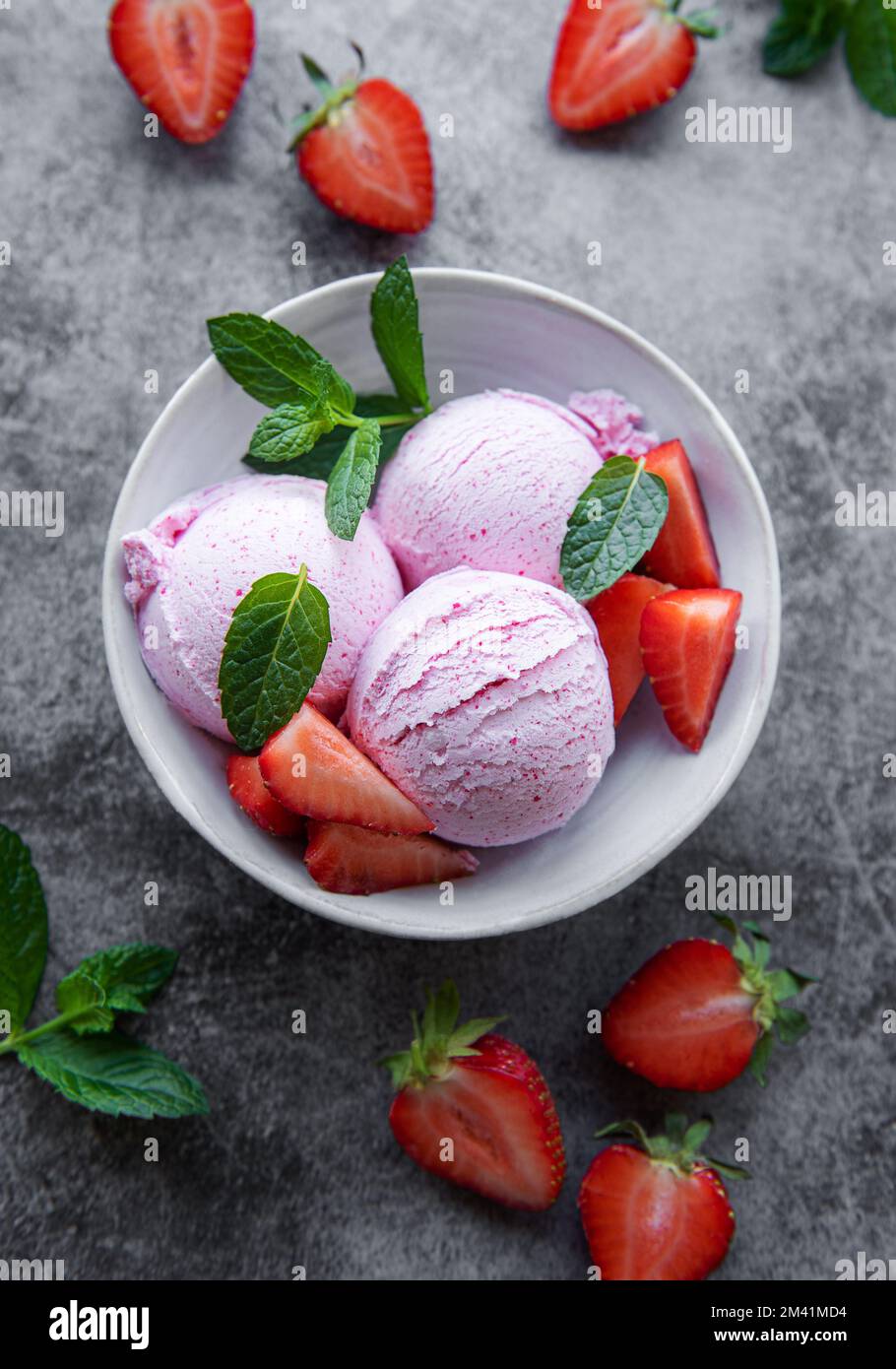 Hausgemachtes Erdbeereis mit frischen Erdbeeren. Süßes Beerendessert im Sommer. Konkreter Hintergrund Stockfoto
