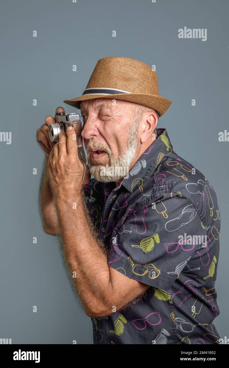 Ein alter Amateurfotograf, der eine kleine Filmkamera benutzt Stockfoto