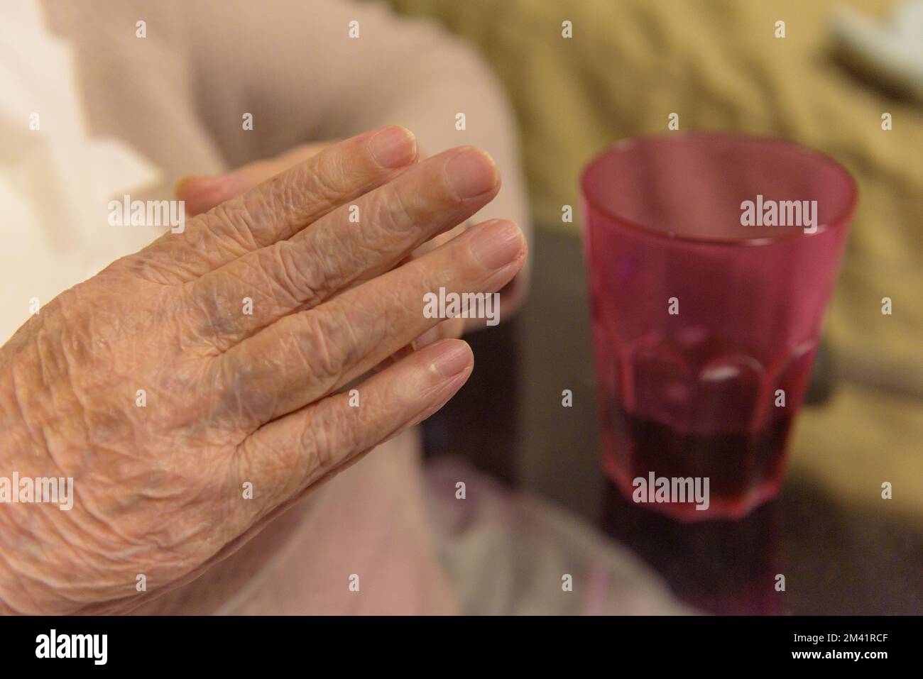 Morbus Parkinson. Die Hand einer älteren Person beim Frühstück Stockfoto