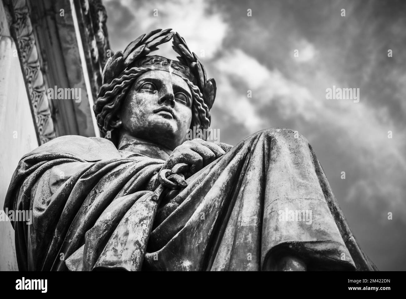 Eine Grauskala der Männerstatue unter einem wolkigen Himmel Stockfoto