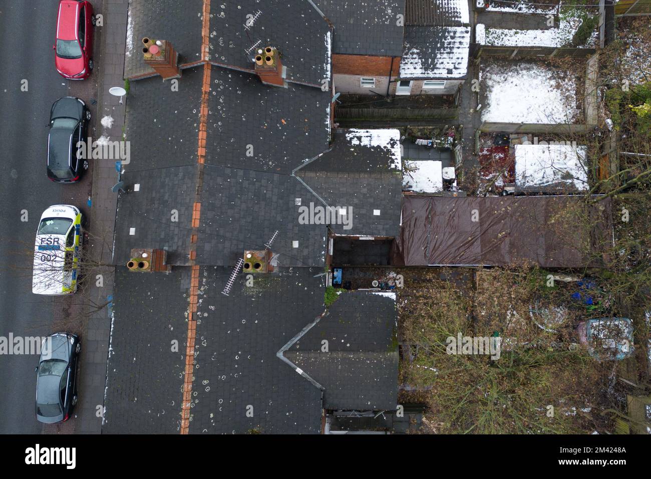 Clarence Road, Handsworth, 18. Dezember 2022. Die Polizei von West Midlands hat bestätigt, dass eine Leiche eines Kindes im Garten eines Anwesens an der Clarence Road in Handsworth, Birmingham, gefunden wurde. Die Polizei ist weiterhin auf dem Terrassengrundstück stationiert, wo florale Tribut an einem Tor, das zu den hinteren Gärten führt, hinterlassen wurden. Ein Grundstück hinter dem Haus wurde mit brauner Plane bedeckt, die den Tatort bedeckt. Ein 40- und 41-jähriger Mann wurde wegen Vernachlässigung angeklagt, weil er den Tod eines Kindes verursacht oder zugelassen hat. Quelle: Stop Press Media/Alamy Live News Stockfoto