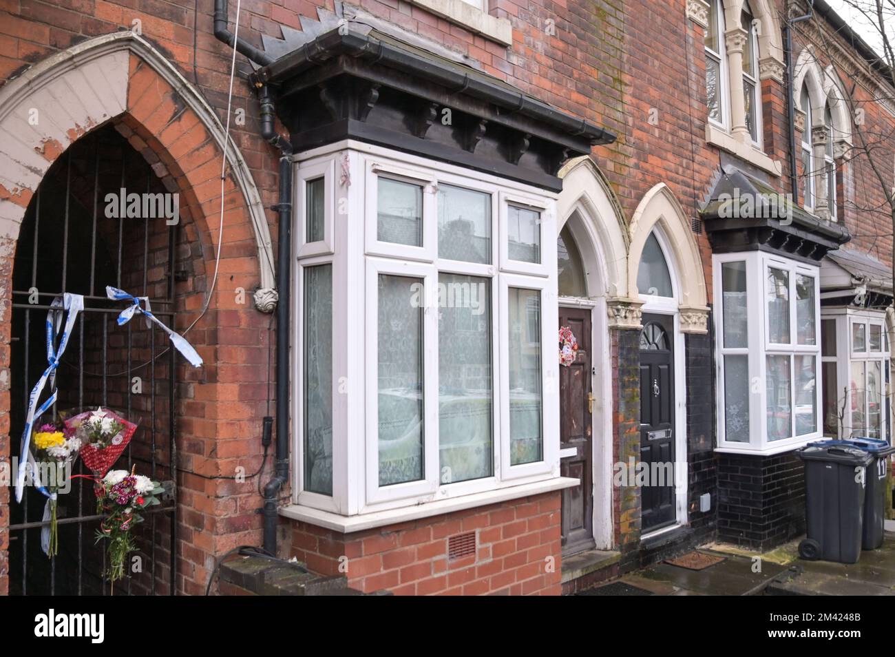 Clarence Road, Handsworth, 18. Dezember 2022. Die Polizei von West Midlands hat bestätigt, dass eine Leiche eines Kindes im Garten eines Anwesens an der Clarence Road in Handsworth, Birmingham, gefunden wurde. Die Polizei ist weiterhin auf dem Terrassengrundstück stationiert, wo florale Tribut an einem Tor, das zu den hinteren Gärten führt, hinterlassen wurden. Ein Grundstück hinter dem Haus wurde mit brauner Plane bedeckt, die den Tatort bedeckt. Ein 40- und 41-jähriger Mann wurde wegen Vernachlässigung angeklagt, weil er den Tod eines Kindes verursacht oder zugelassen hat. Quelle: Stop Press Media/Alamy Live News Stockfoto