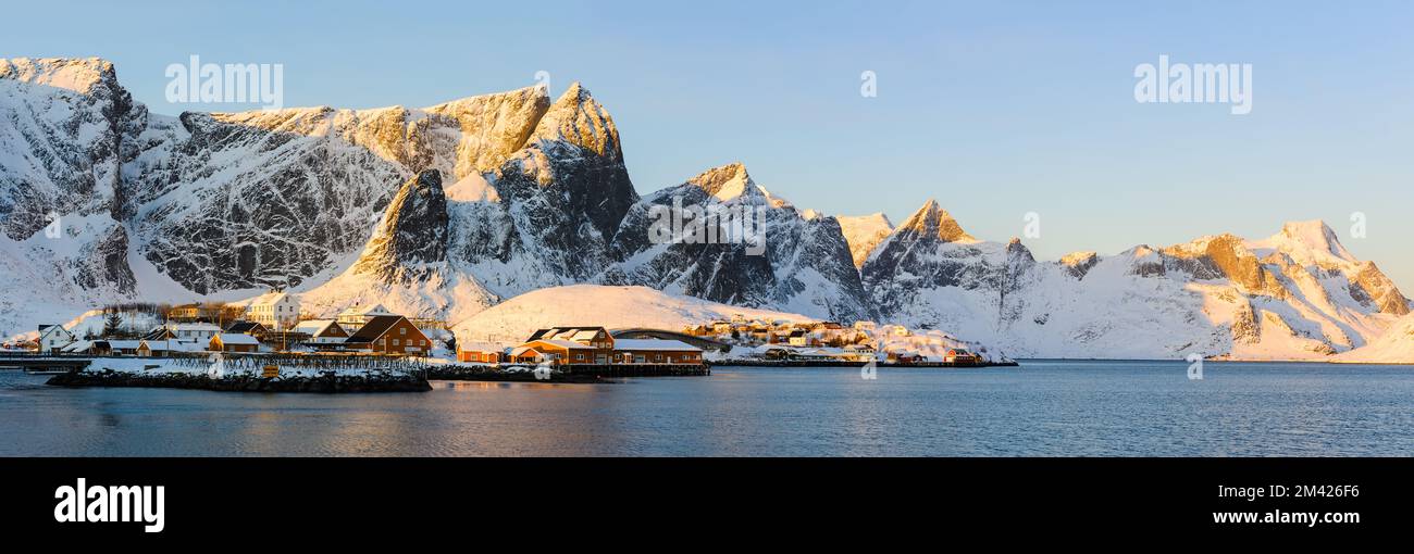 Dorf vor schneebedeckten Bergen im Winter, Lofoten Inseln, Norwegen. Stockfoto