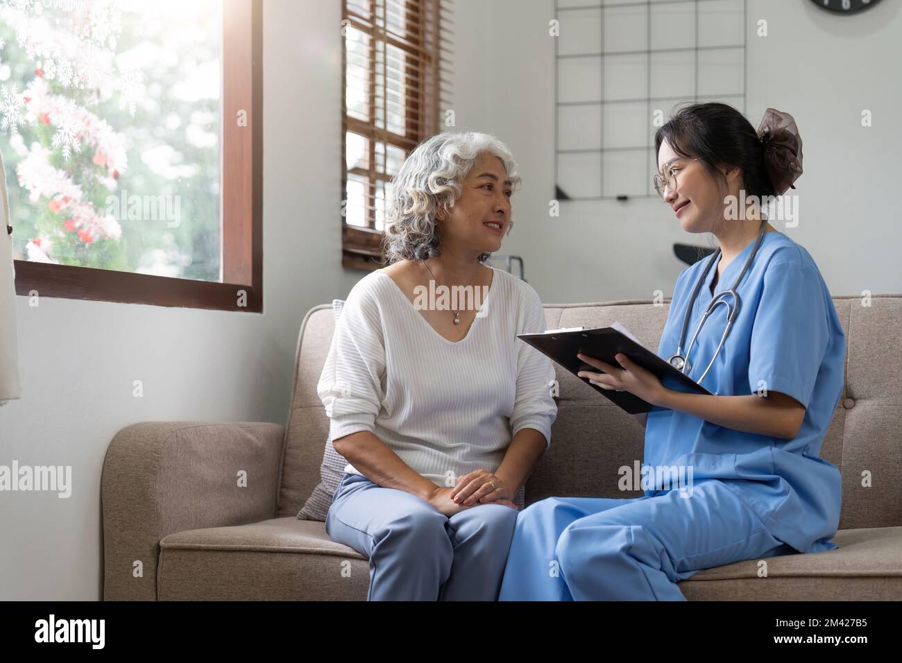 Asiatische Seniorin Patientin auf Sofa mit Ärztin Frau trägt Stethoskop-Diagnose Stockfoto