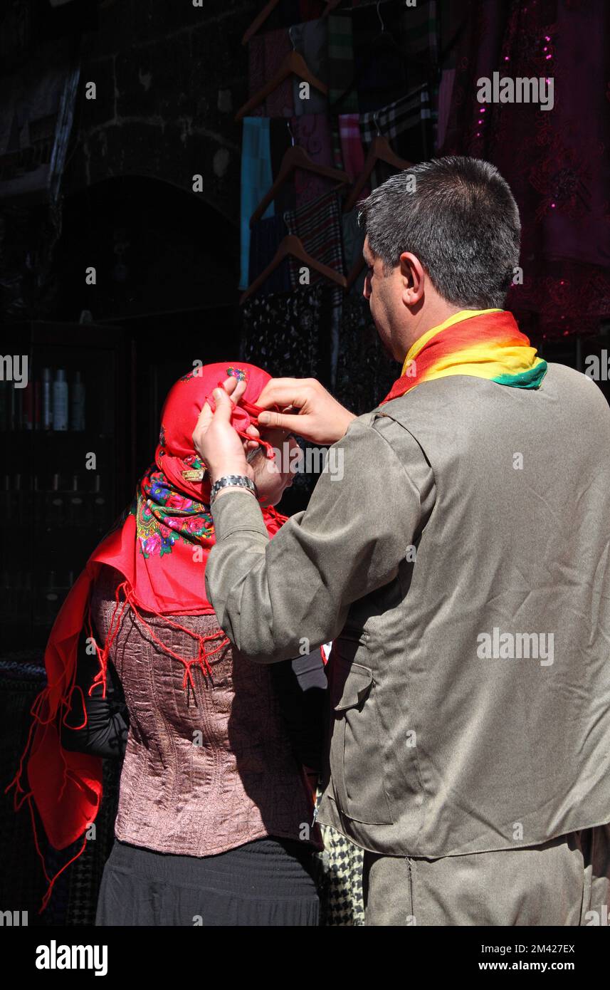 Ein Kurdenmann bindet den Schal seiner Tochter beim Newroz, dem traditionellen Neujahrsfest des Frühlings, in Diyarbakir, Südosttürkei Stockfoto