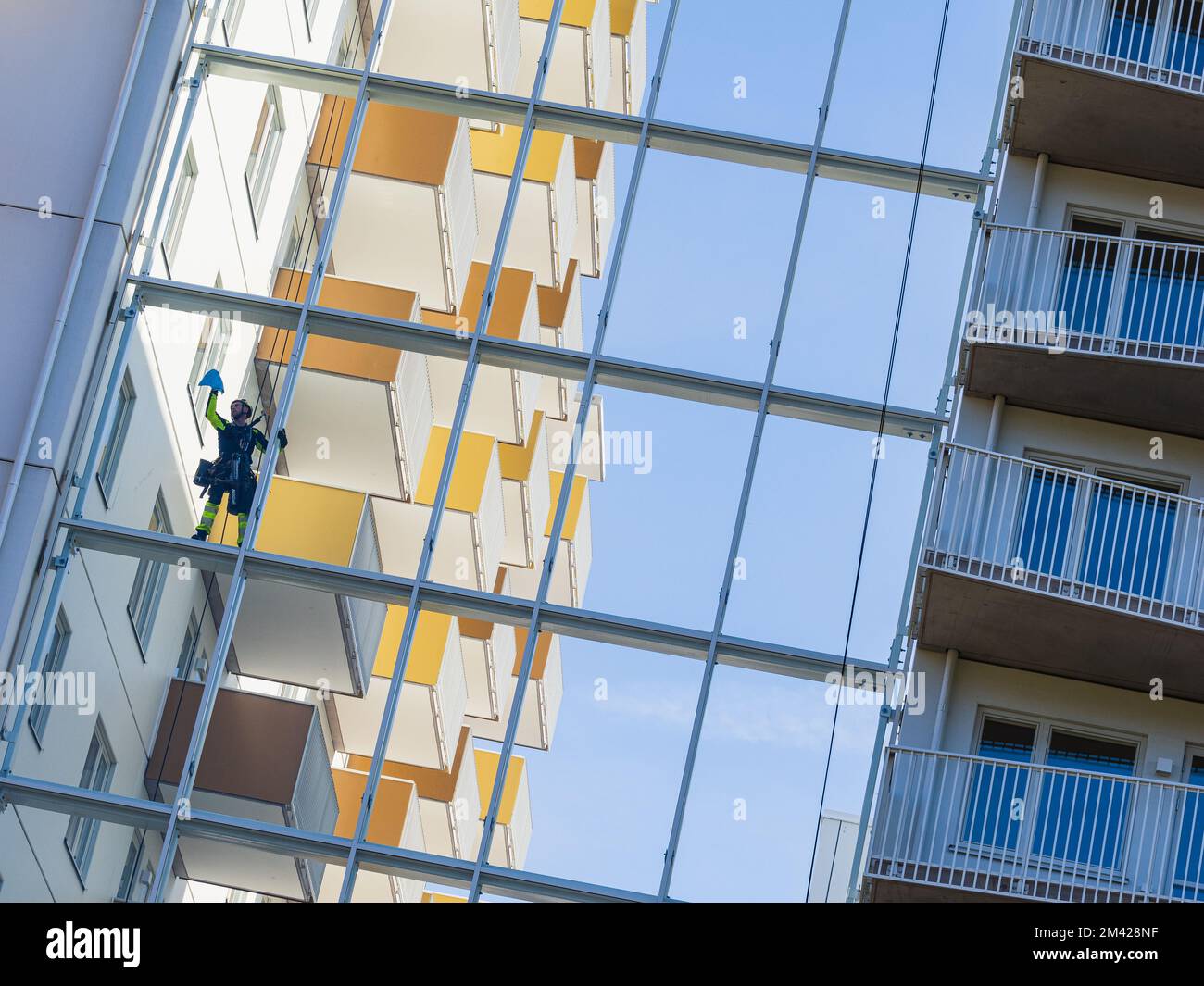 Fensterreiniger hängt an Seilen an einem Gebäude Stockfoto