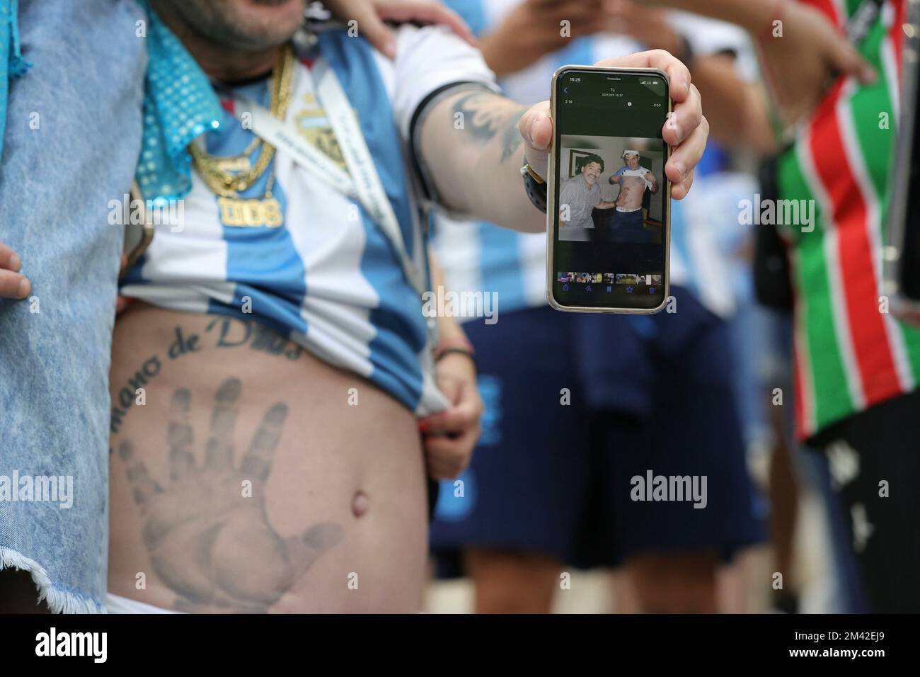Doha, Katar. 18.. Dezember 2022. firo: 12/18/2022, Fußball, FIFA-WELTMEISTERSCHAFT 2022 KATAR, Weltmeisterschaft 2022 Katar, Weltmeisterschaft 2022 Katar, Finale, Finale Argentinien, Argentinien, ARG - Frankreich . Frankreich, FRA-Fan, Argentinien mit Tattoo, Tattoo der Hand Gottes auf dem Bauch, mit Beweisfoto auf dem Handy seines Idols Diego Maradona, neugierig, Witz, Humor, tatoo, tattoo Credit: dpa/Alamy Live News Stockfoto