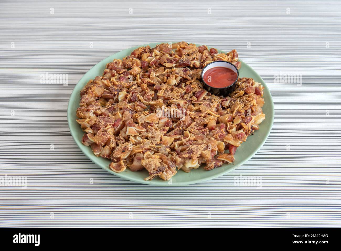 Ein wunderbarer, typisch spanischer Tapa mit gegrilltem Schweinsohr mit Sauce Stockfoto