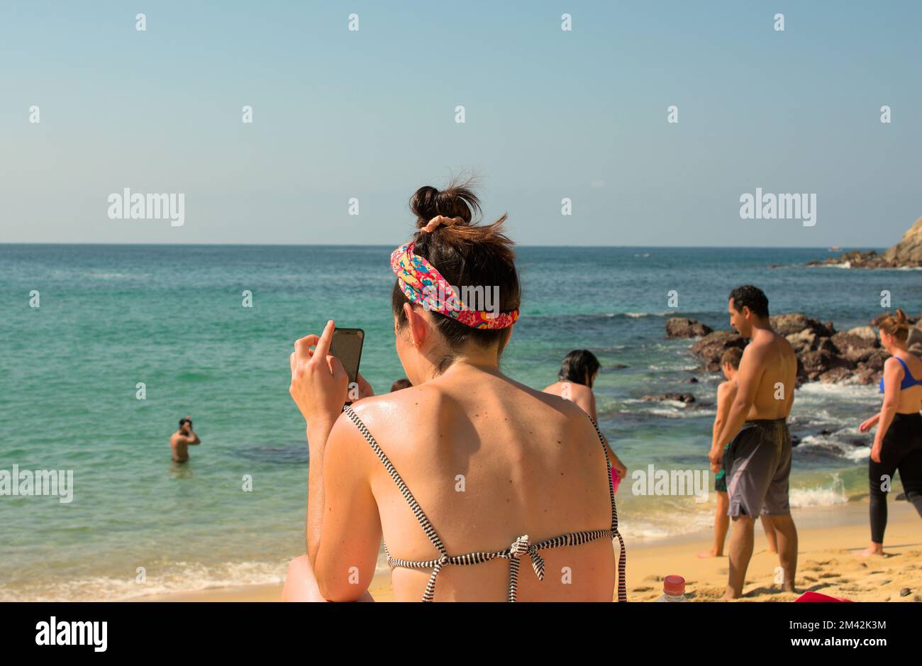 Frau, die ein Foto vom Strand in Puerto Escondido, Mexiko macht Stockfoto