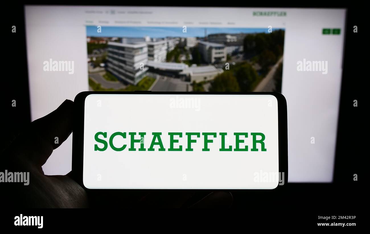 Person, die ein Smartphone mit dem Logo des Unternehmens Schaeffler Technologies AG Co. Hält KG auf dem Bildschirm vor der Website. Konzentrieren Sie sich auf das Display des Telefons. Stockfoto