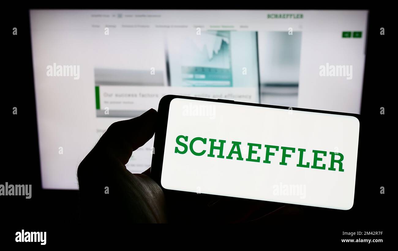 Person, die ein Mobiltelefon mit dem Logo der Schaeffler Technologies AG Co. Hält KG auf dem Bildschirm vor der Unternehmenswebseite. Konzentrieren Sie sich auf das Display des Telefons. Stockfoto
