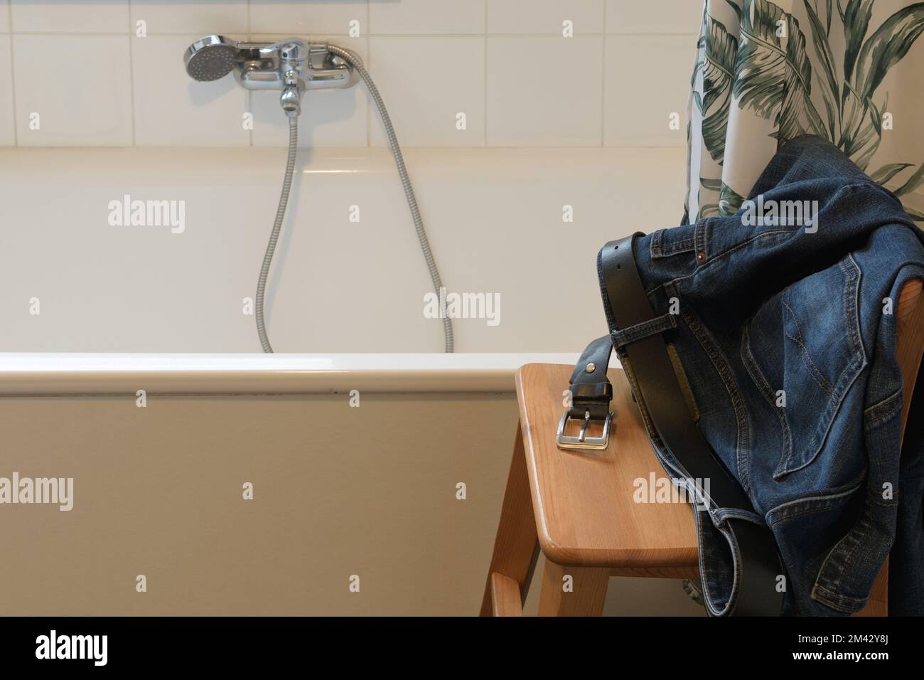 Eine Badewanne und Jeans von jemandem. Vor dem Baden oder Duschen. Stockfoto