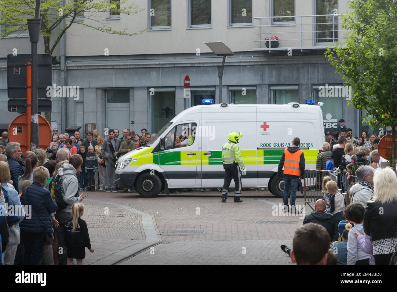 Genk. Limburg-Belgien 01-05-2022. Ein Krankenwagen fährt durch eine Menschenmenge. Während der O-PARADE braucht jemand dringend medizinische Hilfe. Stockfoto