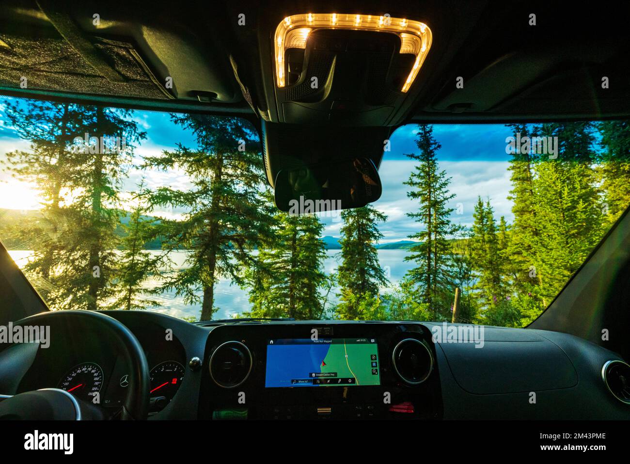 Blick des Fahrers auf den Dease Lake bei Sonnenuntergang; Airstream Interstate 24X 4WD Campervan; Waters Edge Campground; British Columbia; Kanada Stockfoto