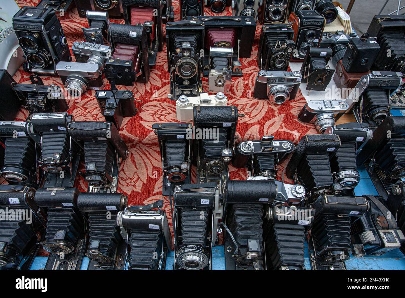Ein Haufen alter Oldtimer-Kameras auf einem Tisch auf einem Flohmarkt in London, Großbritannien. Stockfoto