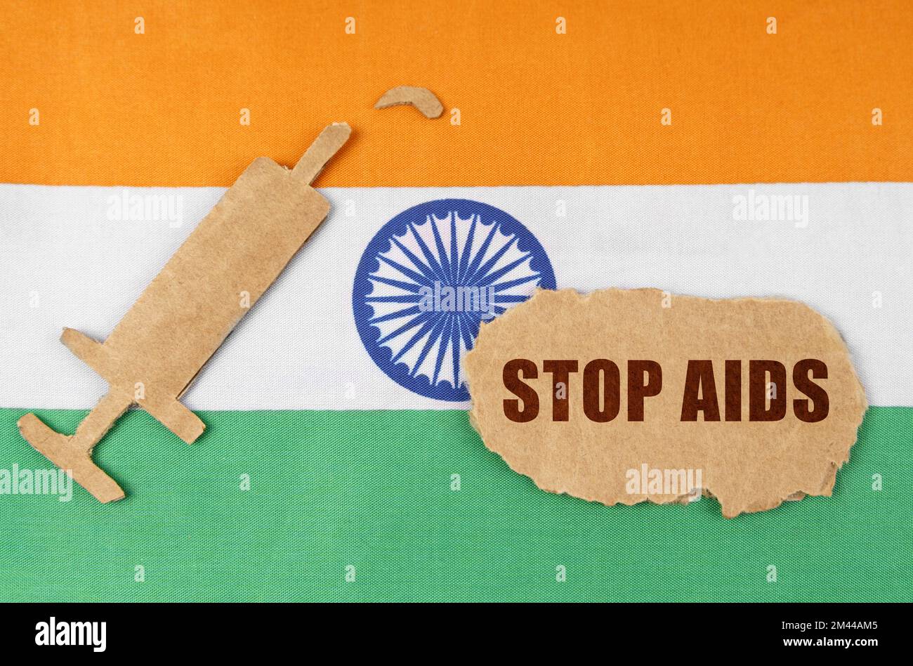 Medizinisches Konzept. Auf der Flagge Indiens, eine Pappfigur einer Spritze und ein zerrissener Pappe mit der Inschrift - STOPP AIDS Stockfoto