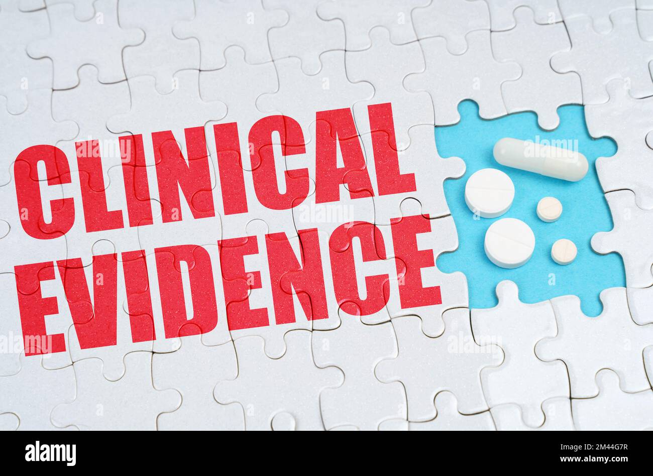 Medizinisches Konzept. Auf den Rätseln ist eine Inschrift - klinischer Beweis, auf einer blauen Hintergrundpille. Stockfoto