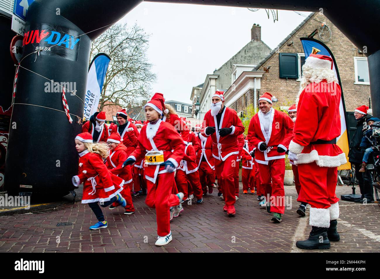 Breda, Niederlande. 18.. Dezember 2022. Die erste Gruppe von Kindern wird ausgeführt. Heute finden in vielen Städten in Ländern der ganzen Welt Santa Run-Veranstaltungen statt. In der niederländischen Stadt Breda liefen zweihundert Menschen, einschließlich Eltern mit ihren Kindern, während der Rotary Santa Run rund 3 km in Weihnachtskostümen. Die einmal jährlich stattfindende Veranstaltung wurde von der Stiftung „Rotary Santa Run“ organisiert. Die Veranstaltung brachte mindestens 8.000â‚¬ für zwei lokale Wohltätigkeitsorganisationen, die Stiftung "Youth Breakfast Breda Foundation" und die Stiftung "Het Bonte Perdje", ein, die jungen Menschen mit Behinderungen die Möglichkeit zum Praktizieren bieten soll Stockfoto