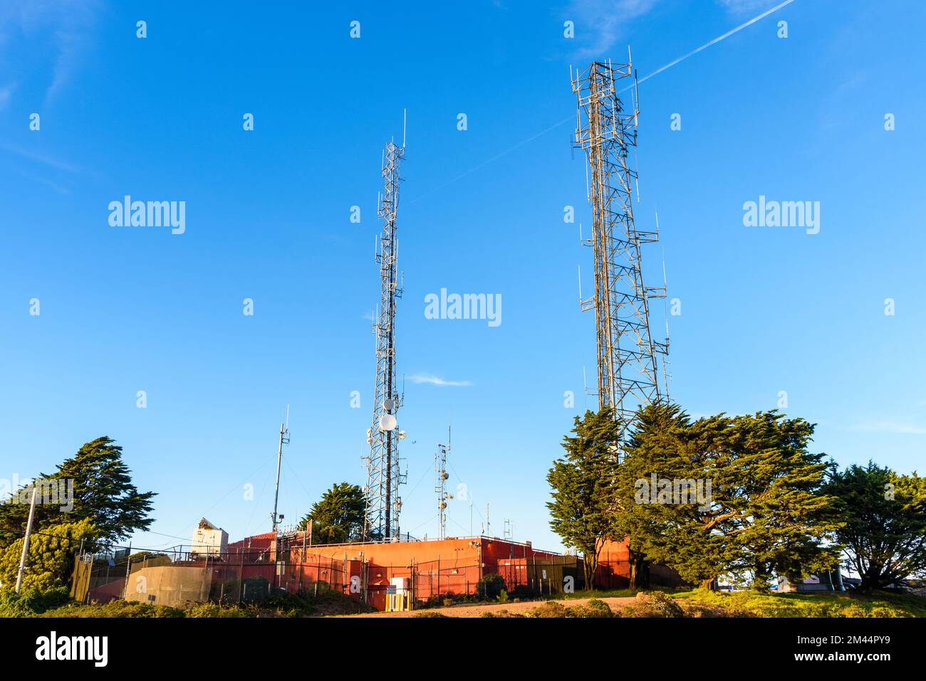 Telekommunikationsantennen auf einem Hügel unter klarem Himmel bei Sonnenuntergang Stockfoto