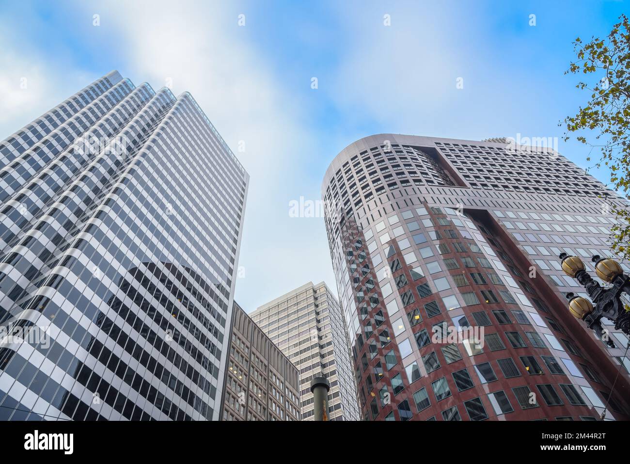 Niedriger Winkel mit Blick auf hohe Bürogebäude vor blauem Himmel und Wolken im Herbst Stockfoto