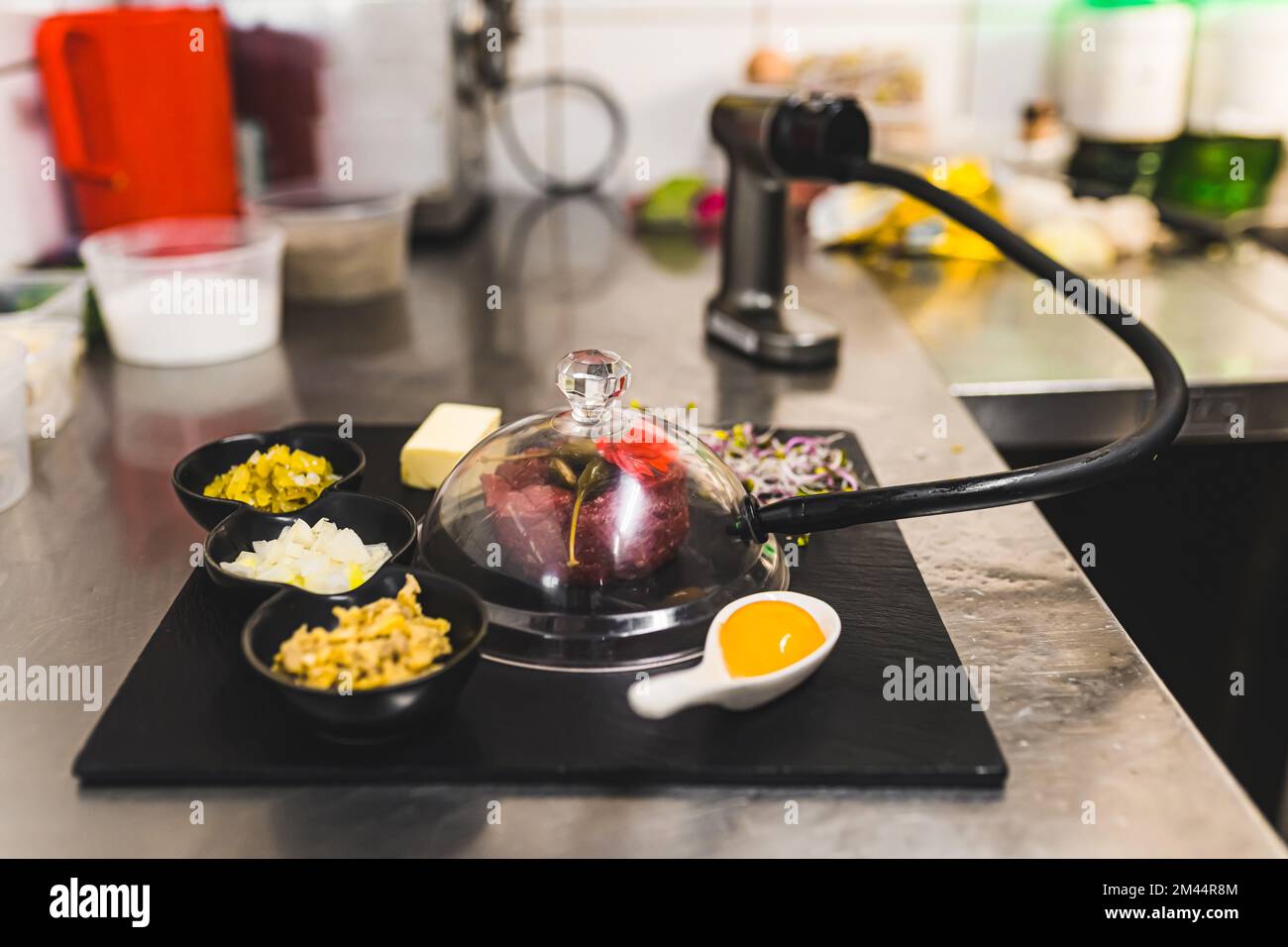 Geräucherte Rindertörtchen auf schwarzem Teller. Restaurant Küche Interieur. Molekulare Gastronomie und traditionelle polnische Küche. Hochwertiges Foto Stockfoto