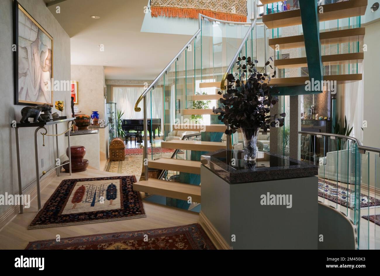 Glas-, Metall- und Holztreppe in einem luxuriös dekorierten und möblierten modernen Haus. Stockfoto