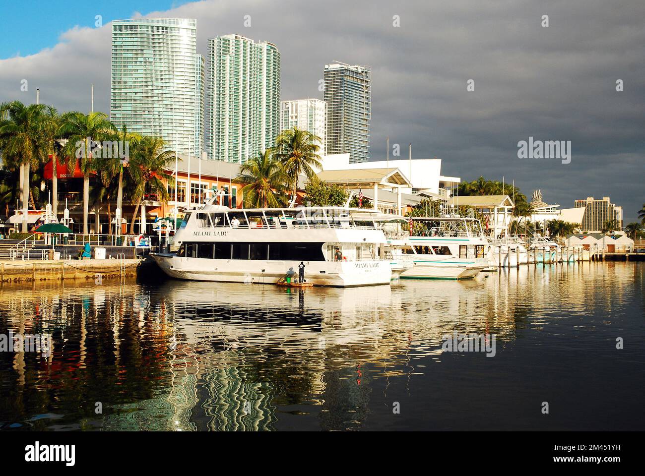 Der Himmel beginnt sich in der Nähe von Miamis Bayside Marina zu erheben, mit Tourbooten, Schiffen und Segelbooten, die an den Docks festgemacht sind Stockfoto