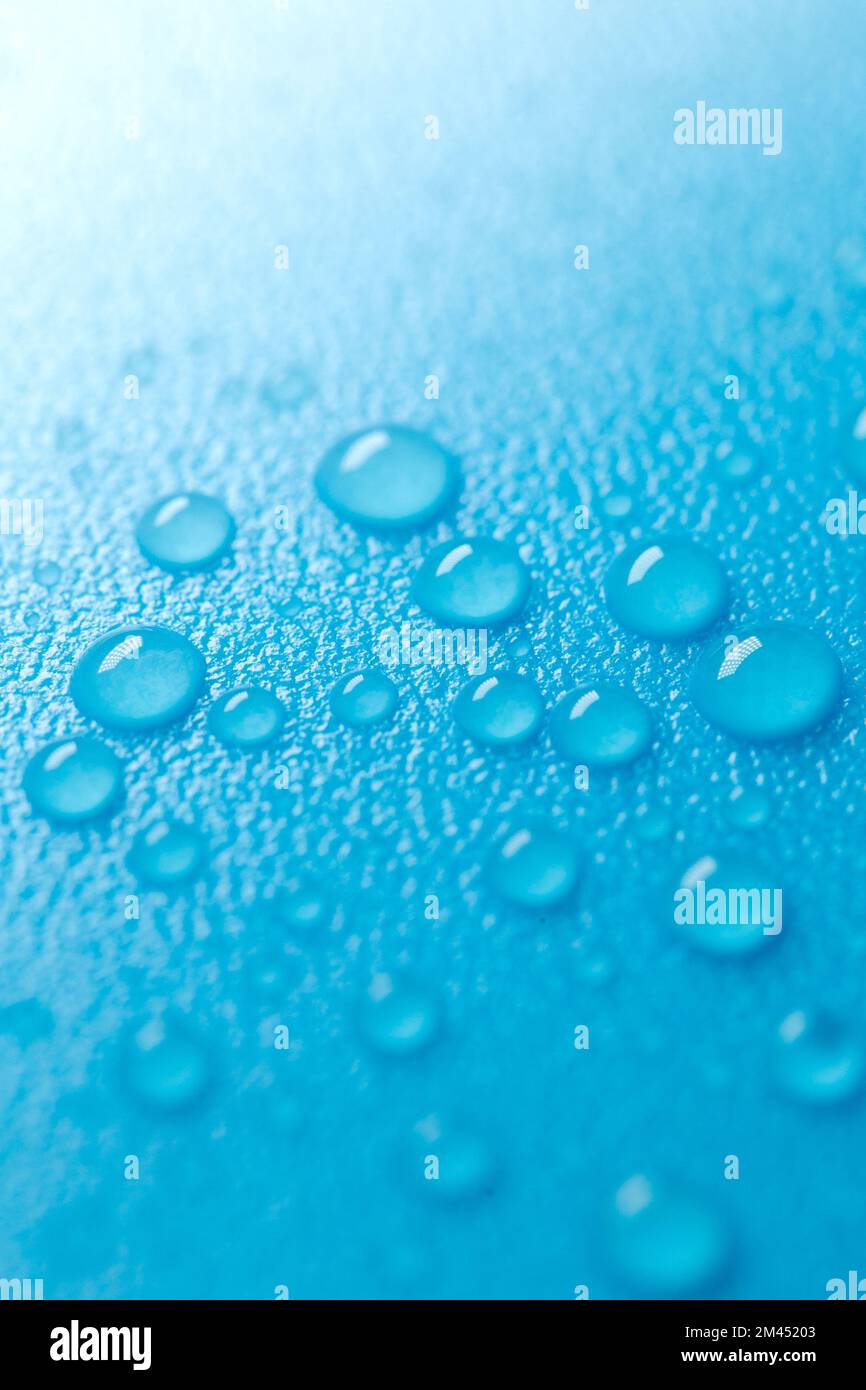 Tropfen auf blauem Hintergrund mit weißem Verlauf.Fluidtextur in kaltblauen Tönen.Hintergrundbild blau Phone.Macro Tropfen.Wasser Tropfen Hintergrund. Stockfoto