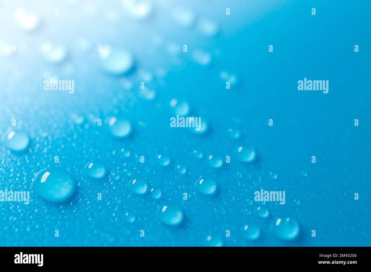Wasser tropft auf blauem Hintergrund mit weißem Verlauf.Fluidstruktur in kalten Tönen.Hintergrund blau Telefon.Makro Tropfen gesetzt Stockfoto