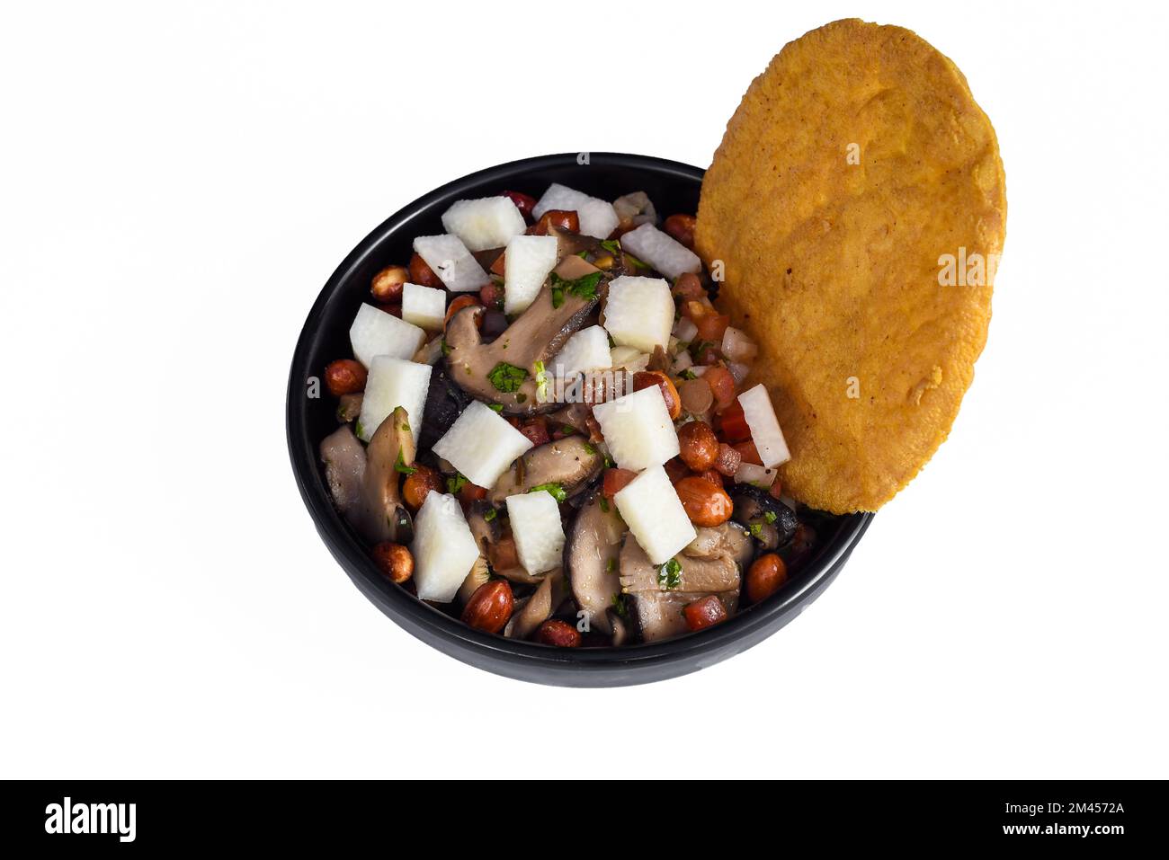 Mexikanisches Gericht Roma auf schwarzem Teller mit Blick von oben mit Kirschtomaten und Chili-Pfeffer isoliert auf weißem Hintergrund Stockfoto
