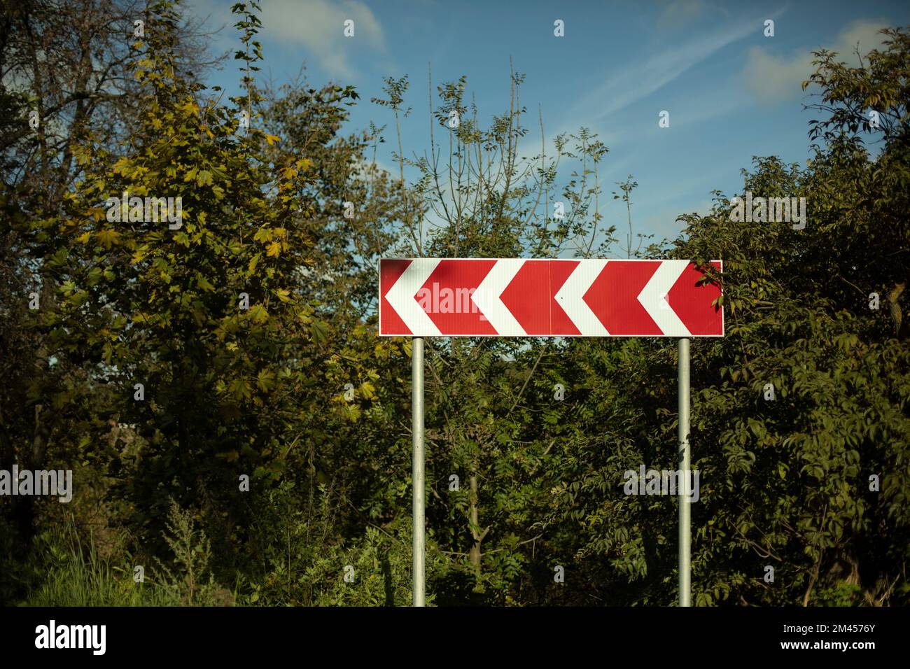 Scharfe Kurve. Scharfes Wendezeichen. Autobahninfrastruktur. Rotes Straßenschild mit Pfeilen nach links. Stockfoto
