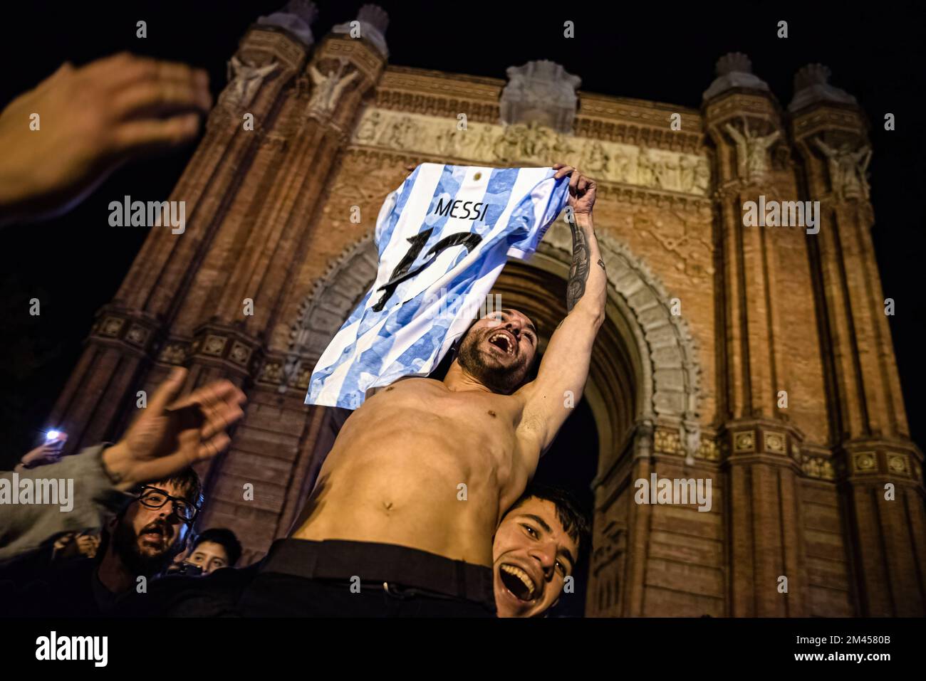 Barcelona, Spanien. 18.. Dezember 2022. Ein Argentinier hält während der Feierlichkeiten einen anderen Mann mit einem Lionel Messi-Shirt im Arc de Triomphe in Barcelona aus. Mehr als 2.000 Argentinier überschwemmten Barcelonas Triumphbogen mit einer Weltmeisterschaft, um zu feiern, dass sie nach dem Elfmeterschießen in Katar Frankreich geschlagen haben. (Foto: Ximena Borrazas/SOPA Images/Sipa USA) Guthaben: SIPA USA/Alamy Live News Stockfoto