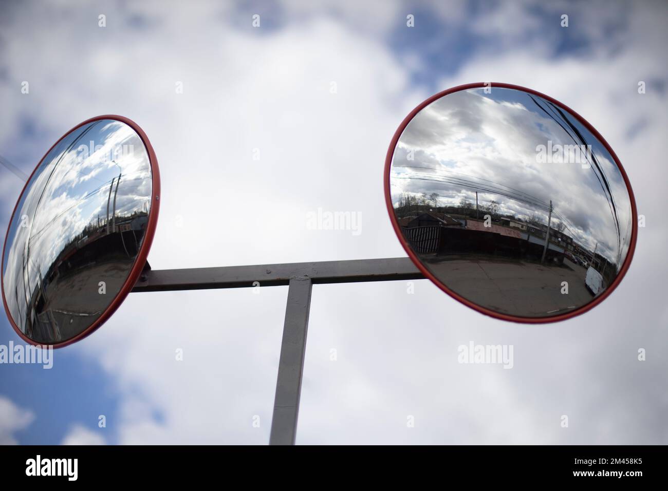 Runder Spiegel auf dem Parkplatz. Spiegel zur Beobachtung. Reflektierende Oberfläche. Stockfoto