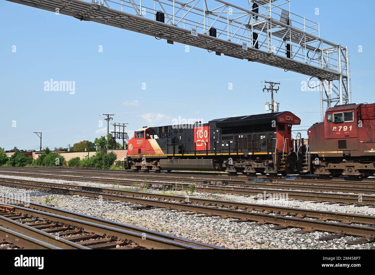 Franklin Park, Illinois, USA. Lokomotiven, angeführt von einer kanadischen Eisenbahneinheit, treiben einen Güterzug in Richtung eines Bahnhofs an. Stockfoto
