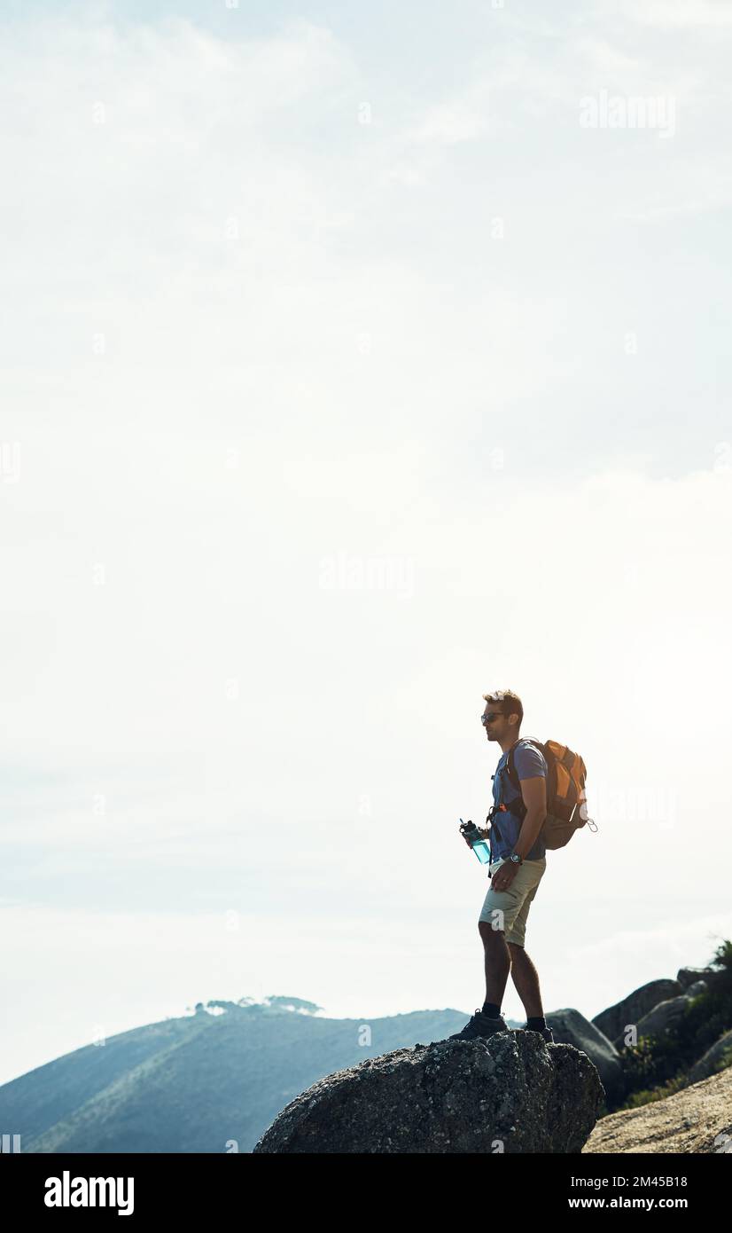 Das ist es also. Ein sorgenloser junger Mann, der nach einem Tag voller Wanderungen auf einem Berg steht. Stockfoto