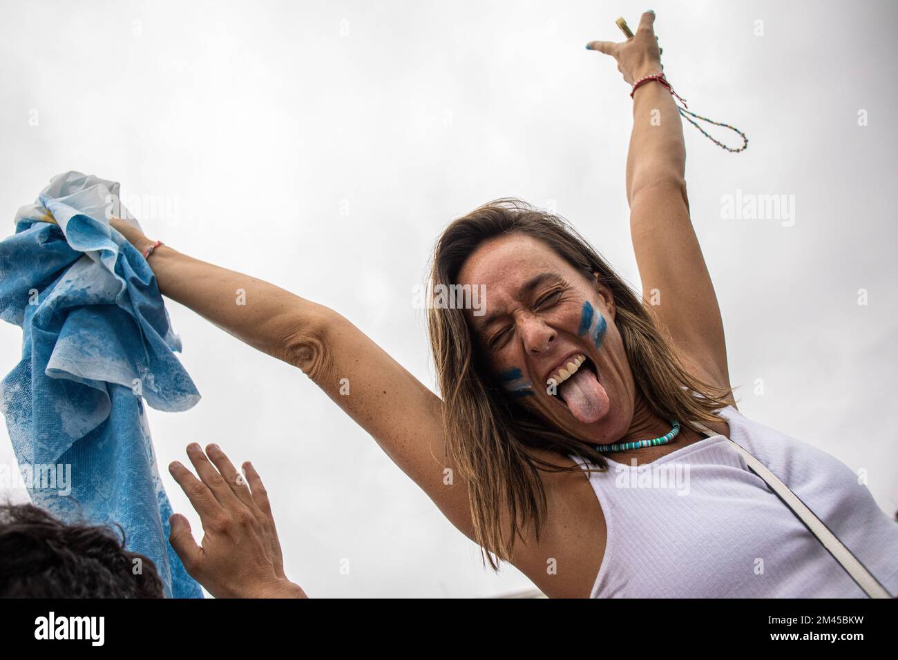 Rio De Janeiro, Brasilien. 18.. Dezember 2022. Eine argentinische Frau feiert Argentiniens Sieg im WM-Finale am Copacabana Beach in Rio de Janeiro. Anlässlich des Endspiels der Weltmeisterschaft in Katar zwischen Argentinien und Frankreich in Rio de Janeiro (Brasilien) versammelten sich Hunderte Argentinier am Strand der Copacabana, um das Spiel zu besuchen und gemeinsam den Sieg zu feiern. Kredit: SOPA Images Limited/Alamy Live News Stockfoto
