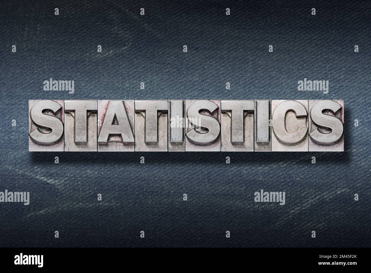 Statistikwort aus Metallic-Buchdruck auf dunklem Jeans-Hintergrund Stockfoto
