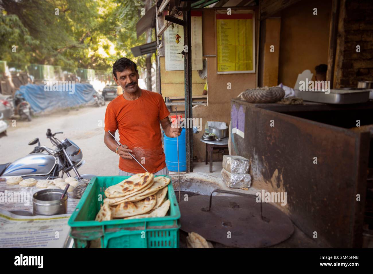 Koch eines lokalen Straßenrestaurants oder einer Dhaba, der Brot oder Roti in einem Tonholzofen oder einem Tandoor macht Stockfoto