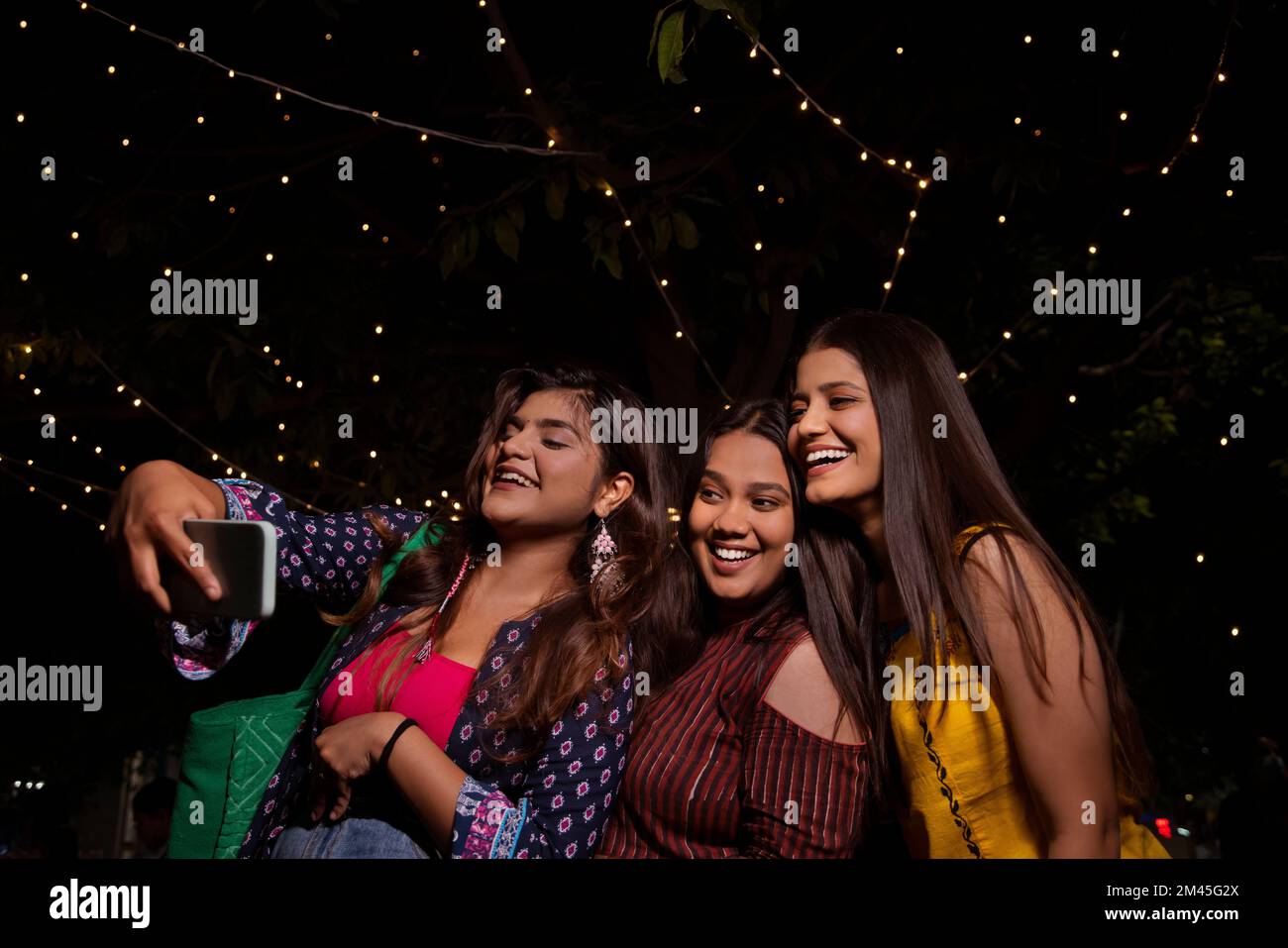Frauen machen nachts Selfie auf der Straße der Stadt Stockfoto